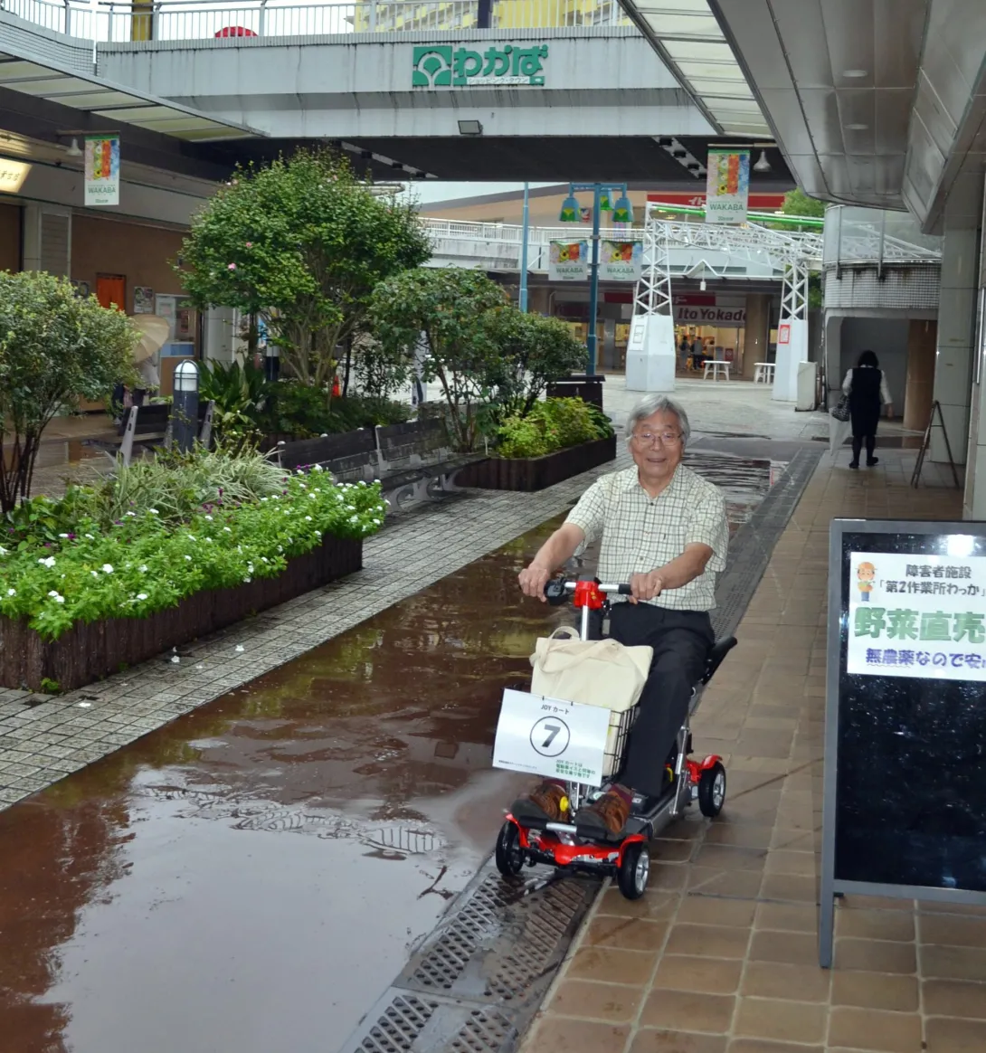 電動カートに乗る認定NPO法人若葉台の白岩さんの写真